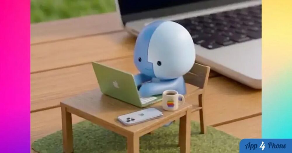 Mascotte bleue travaillant sur un MacBook miniature