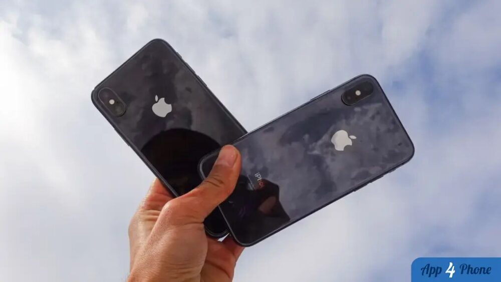 Deux iPhone noirs tenus en main sous le ciel
