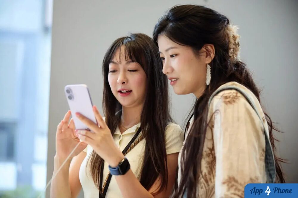Deux femmes regardent un smartphone dans un magasin