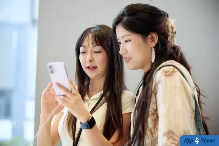 Deux femmes regardent un smartphone dans un magasin