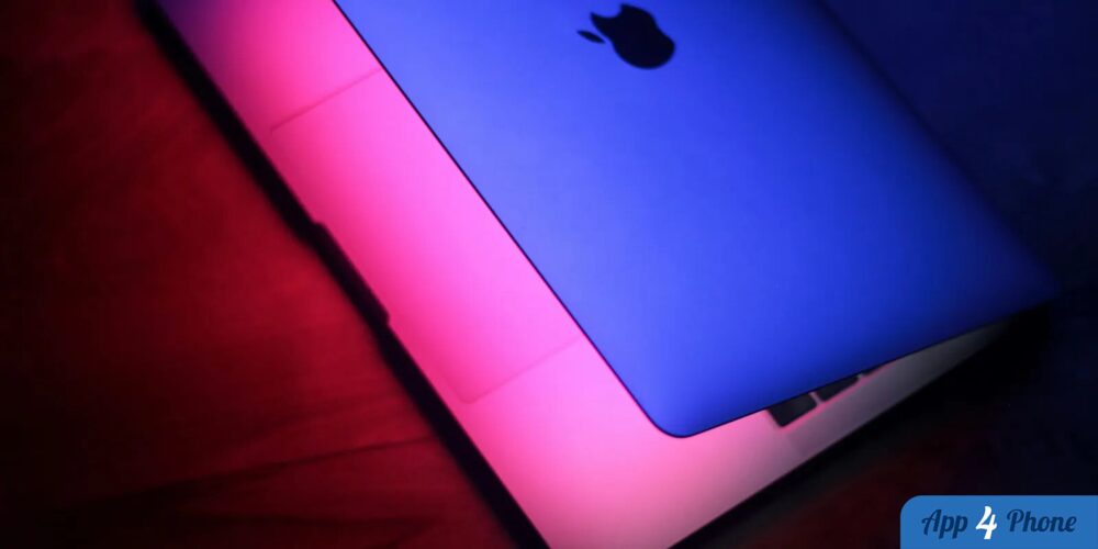 Ordinateur portable Apple éclairé par des lumières bleue et rose