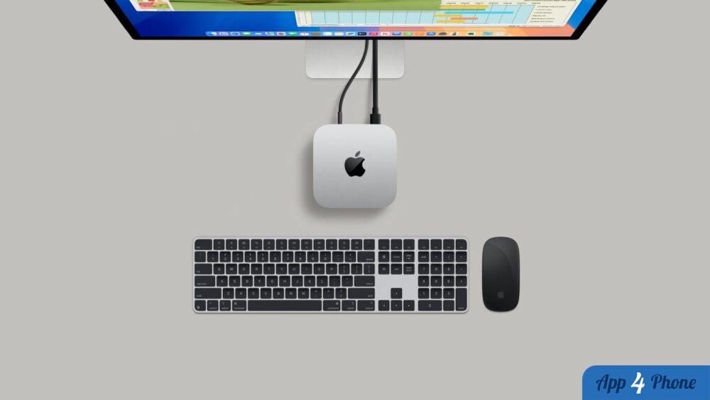 Mac mini Apple installé sous un écran avec clavier et souris