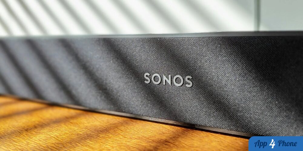 Enceinte connectée Sonos noire posée sur une table en bois
