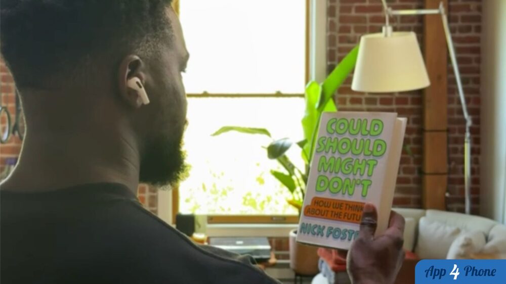 Homme portant des AirPods et lisant le titre d’un livre