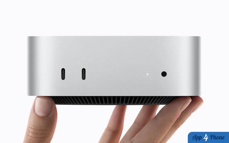 Mac mini argenté tenu entre les mains, avec ports visibles