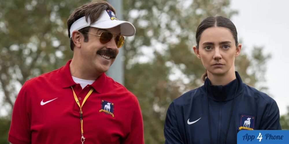 Ted Lasso et une entraîneuse posent côte à côte