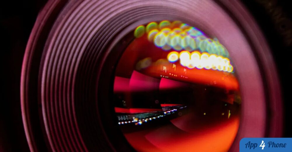 Gros plan sur un objectif photo aux reflets lumineux colorés.