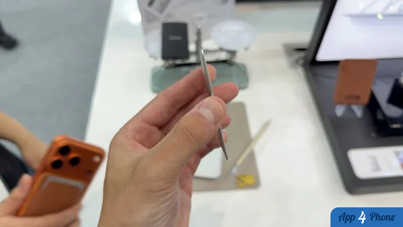 Accessoire métallique fin présenté au-dessus d’un présentoir d’accessoires Apple
