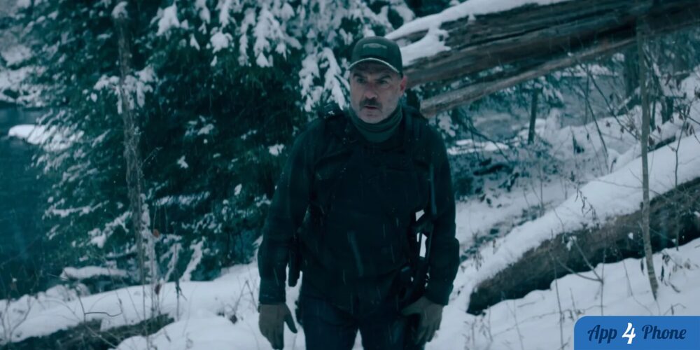 Homme armé avançant dans un paysage forestier enneigé