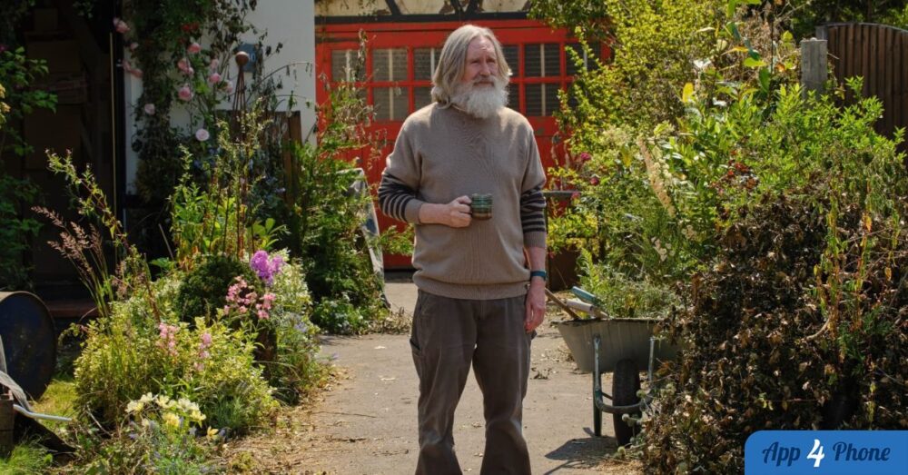 Homme barbu tenant une tasse dans un jardin fleuri