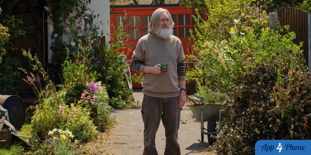 Homme barbu tenant une tasse dans un jardin fleuri