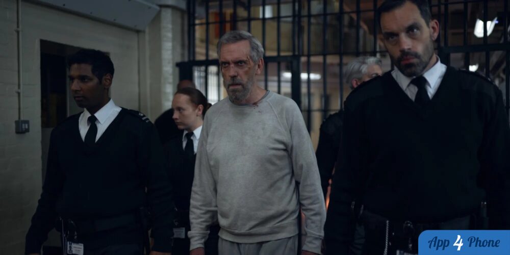 Hugh Laurie escorté par des gardiens de prison