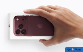 Main tenant un iPhone rouge posé sur sa boîte