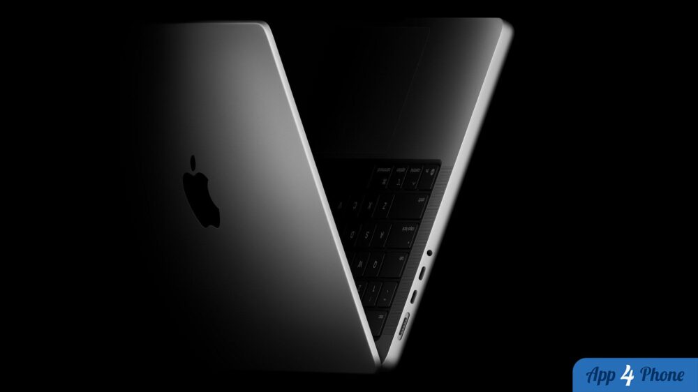 MacBook ouvert vu de dos, présentant son clavier et ses ports latéraux.