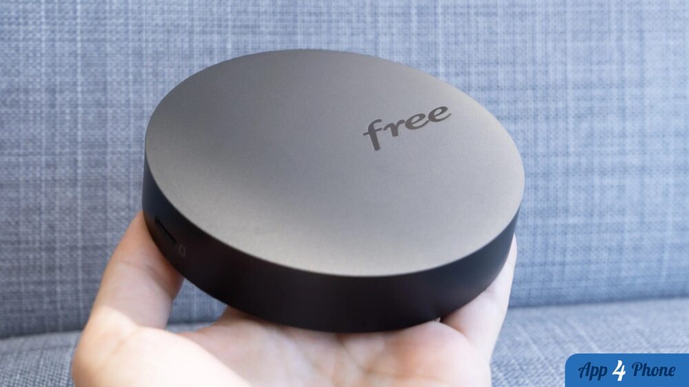 Décodeur Freebox rond tenu dans une main
