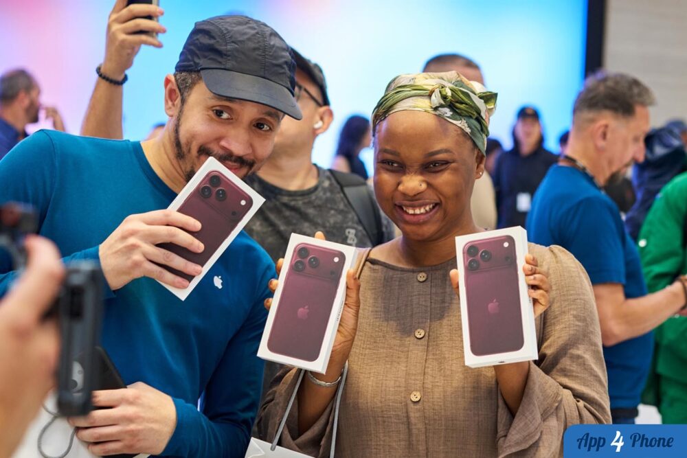 Des acheteurs tiennent des boîtes d’iPhone rouges dans une boutique