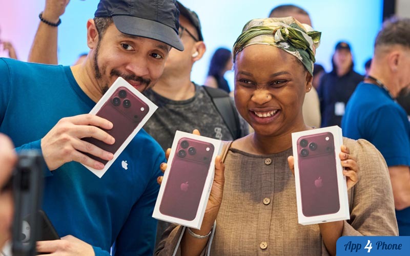 Des clients présentent des boîtes d’iPhone rouges lors d’un événement