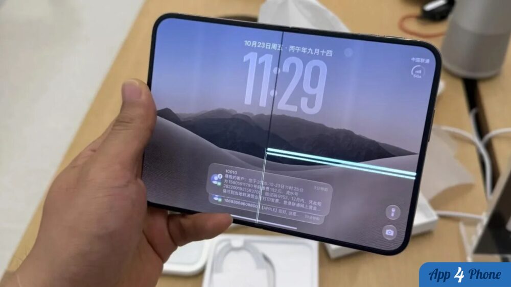 iPhone Duo tenu en main, écran pliable fissuré au centre
