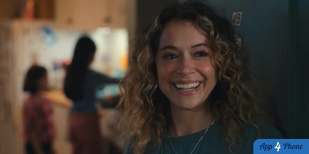 Femme souriante aux cheveux bouclés, dans une scène intérieure