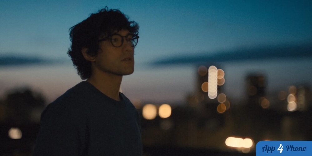 Homme à lunettes regardant les lumières urbaines nocturnes