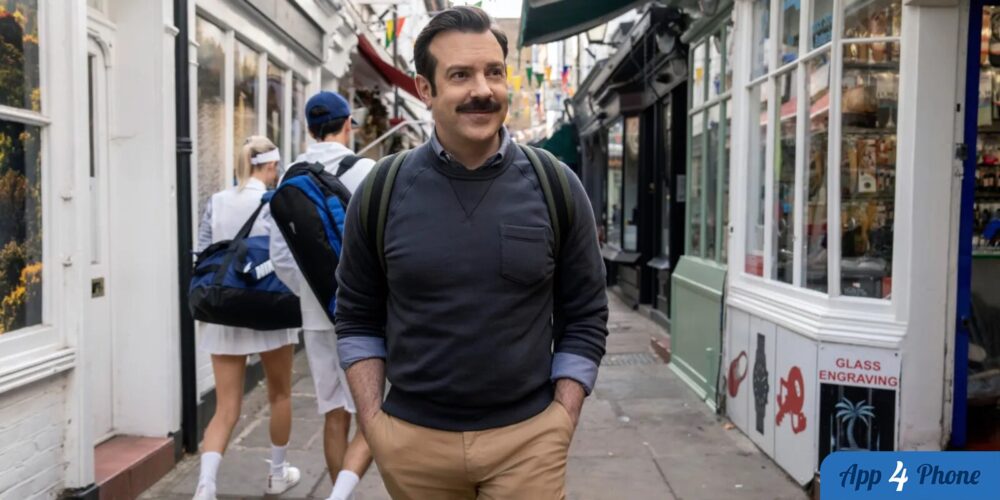 Ted Lasso déambule dans une rue londonienne avec son sac à dos